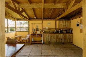 a kitchen with wooden ceilings and a table and chairs at The Cosy Nest Hut in Keddington +22 photos