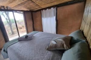 a large bed in a room with a window at Hennies HideOut in Kachikau