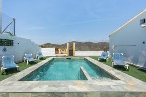 a swimming pool with two chairs at Casa Villazo 1 in Málaga