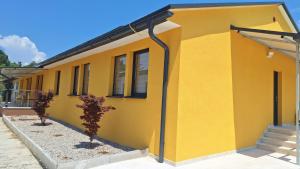 a yellow house with two trees in front of it at Sleep House in Labin