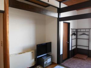 a room with a bunk bed with a tv and a tv stand at New Grande Mimatsu in Takamatsu