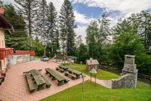 a park with benches and a playground with trees at Holiday Home Happiness in Hočko Pohorje