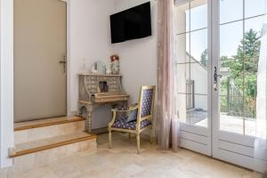 a room with a chair and a television on a wall at La Bastide Des Mereuilles in Orange