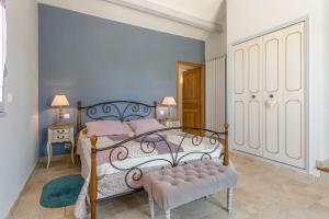 a bedroom with a bed with a bench in it at La Bastide Des Mereuilles in Orange