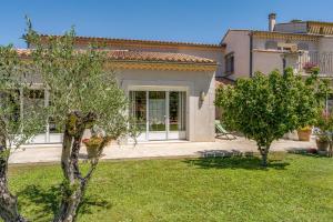 a house with a yard with trees in front of it at La Bastide Des Mereuilles in Orange