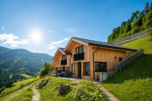 a house on a hill with the sun in the background at Chalet Tschogerhof Tiers am Rosengarten Dolomiten in Tires