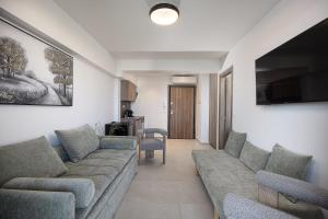 a living room with a couch and a tv at Solianna Rethymno Suites in Rethymno