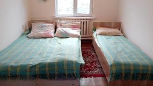 two beds sitting next to each other in a bedroom at House Ali in Chirganak