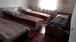 a bedroom with two beds and a window at House Ali in Chirganak +12 photos