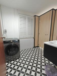 a laundry room with a washer and a black and white floor at D'Monochrome in Singapore
