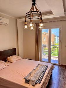 a bedroom with a bed and a chandelier at Sea View 4Bedroom Villa wz Jacuzzi Mountain View Ras Elhikma in Ras Elhekma +97 photos