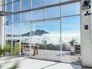 Caldera Hotel & Restaurant في Kintamani: رجل يجلس على طاولة مطلة على جبل