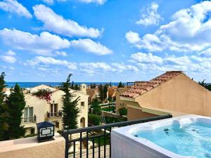 a hot tub on the balcony of a house at Sea View 4Bedroom Villa wz Jacuzzi Mountain View Ras Elhikma in Ras Elhekma
