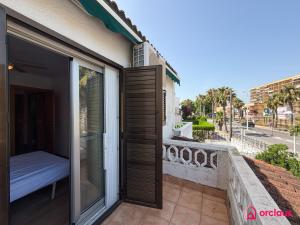 a balcony with a sliding glass door and a bed at House Bloom in Oropesa del Mar