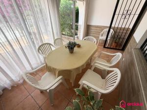 a dining room with a table and white chairs at House Bloom in Oropesa del Mar