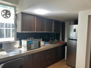 a kitchen with wooden cabinets and a refrigerator at Guest Room Star Avenue in Shah Alam +13 photos