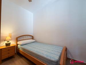 a small bedroom with a bed and a nightstand at House Bloom in Oropesa del Mar