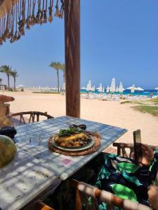 a plate of food sitting on a table at the beach at Sea View 4Bedroom Villa wz Jacuzzi Mountain View Ras Elhikma in Ras Elhekma