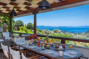 a table on the patio with a view of the ocean at Aenaon Villa with Private Pool Panoramic view in Mileai +71 photos