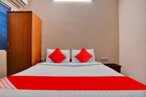 a bedroom with a large bed with red pillows at Hotel O Sudipti Resort in Indore