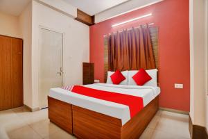a bedroom with a large bed with red pillows at Hotel O Sudipti Resort in Indore