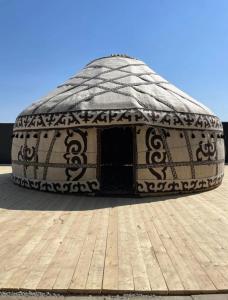 a round igloo building with a wooden floor at Sun Garden Guest House in Ak-Say