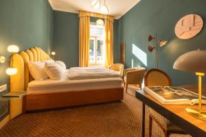 a bedroom with a bed and a desk and a table sidx sidx sidx at the eighteen86 by keyone in Bad Gastein