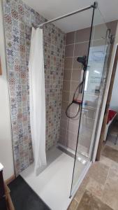 a shower with a glass door in a bathroom at Gîte Lydmalida cocon Ardéchois in Les Ollières-sur-Eyrieux
