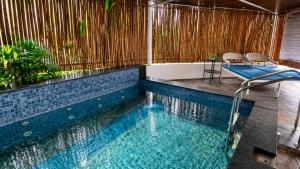 a swimming pool with a table and chairs in it at White Coco Luxury Villas, Private Pool, North Goa in Baga