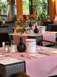 a table with two tables with vases and flowers on it at Seehotel Burg Spreewald in Byhleguhrer Kaupen