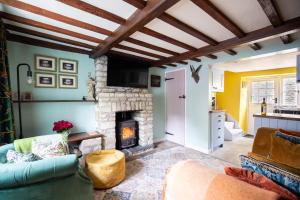 a living room with a fireplace and a couch at Cozy Cotswold Burford Cottage in Burford