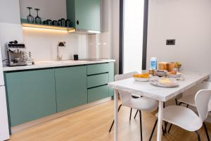 a kitchen with blue cabinets and a table with food on it at iMa-Ge Luxury in Nea Vrasna
