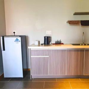 a kitchen with a counter and a refrigerator at family 1 bed room apartment in Malacca