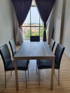 a dining room table with chairs and a large window at family 1 bed room apartment in Malacca +6 photos