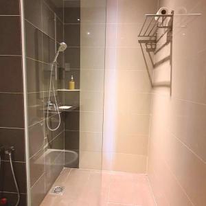 a shower with a glass door in a bathroom at family 1 bed room apartment in Malacca