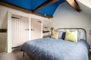 a bedroom with a bed with a blue ceiling at Cozy Cotswold Burford Cottage in Burford