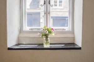 a vase of flowers sitting on a window sill at Cozy Cotswold Burford Cottage in Burford +98 photos