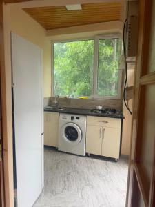 a kitchen with a washing machine and a window at Cozy house in Sheki +11 photos