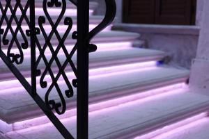 a set of stairs with a gate with purple lights at Relais V&G in Anagni