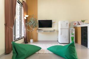 a living room with green pillows and a refrigerator at Calma Villa Panorama, Batu Malang in Batu