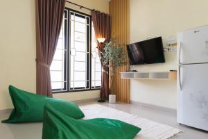 a living room with a green couch and a window at Calma Villa Panorama, Batu Malang in Batu