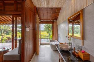 a bathroom with a sink and a large window at Aranya Ubud Villa in Ubud