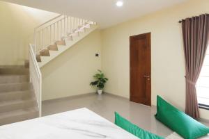 a room with a staircase and green pillows at Calma Villa Panorama, Batu Malang in Batu