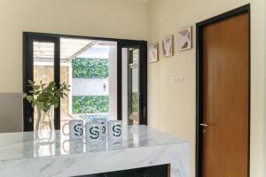 a kitchen with a white counter and a glass door at Calma Villa Panorama, Batu Malang in Batu