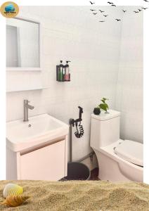 a white bathroom with a sink and a toilet at Aqua Vista Merang in Kampung Merang +46 photos