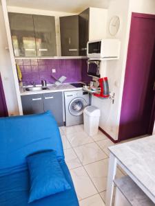 a kitchen with a blue couch in a room at Appartement cosy à Gruissan, piscine partagée, 25 m² in Gruissan