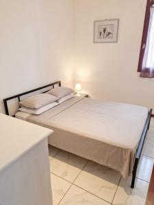 a bedroom with a bed in a white room at Appartement cosy à Gruissan, piscine partagée, 25 m² in Gruissan +7 photos