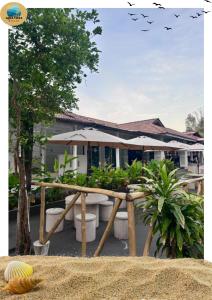 a house with plants and umbrellas in front of it at Aqua Vista Merang in Kampung Merang