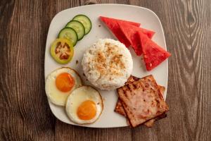 a plate of food with eggs and vegetables on a table at Kokotel Cebu Capitol in Cebu City