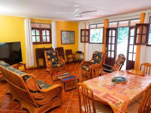 a living room with a wooden table and chairs at Maison charmante à Pointe Noire, vue montagne, jardin privé in Pointe-Noire